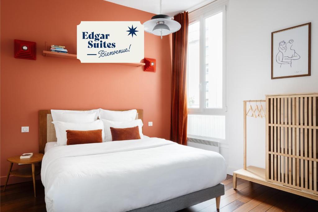 - une chambre avec un lit blanc et un panneau mural dans l'établissement Edgar Suites Louvre - Saint-Honoré, à Paris