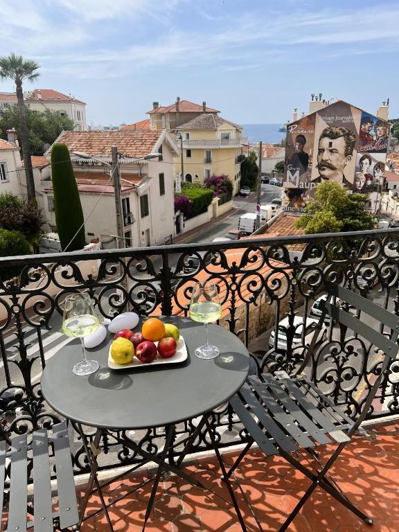 - une table avec une assiette de fruits et des verres à vin sur le balcon dans l'établissement Luxury Cannes, à Cannes