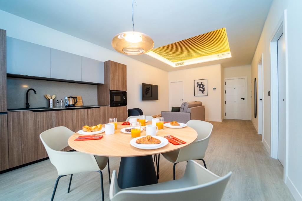 ein Esszimmer und eine Küche mit Tisch und Stühlen in der Unterkunft Edificio Reyes Católicos Alicante Centro by Renthas in Alicante