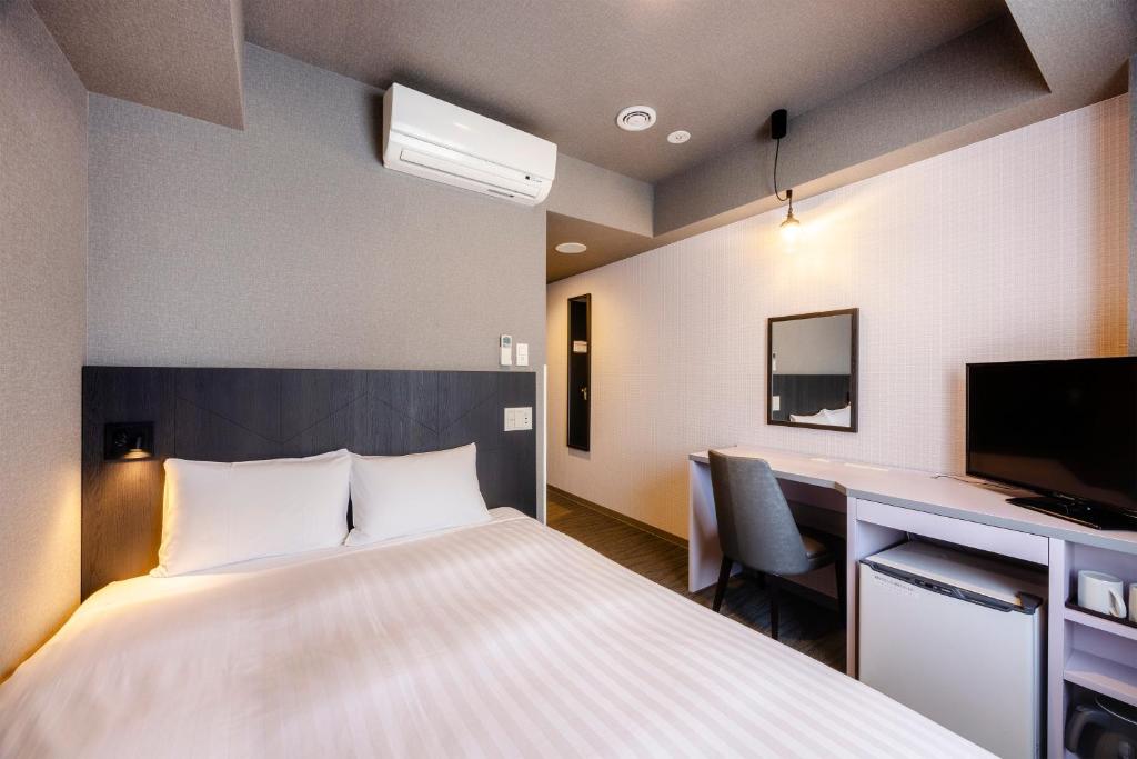 Postel nebo postele na pokoji v ubytování Hotel Wing International Shimbashi Onarimon
