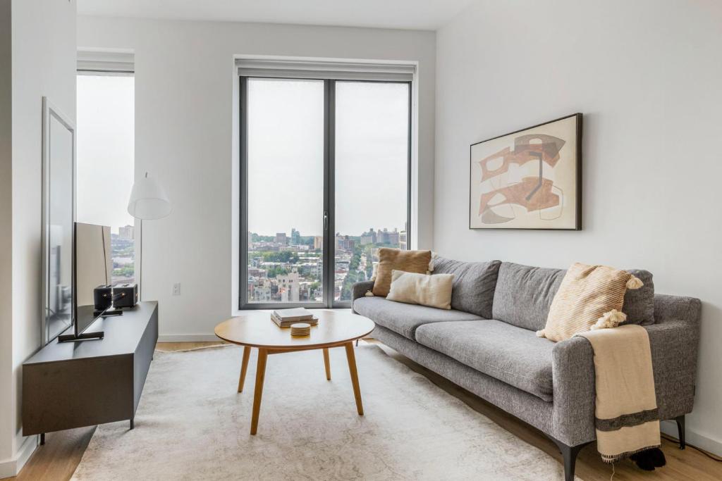a living room with a couch and a table at Blueground Clinton Hill roof pool doorman wd NYC-1550 in Brooklyn