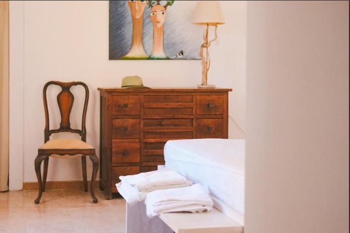 a bedroom with a dresser and a bed and a chair at Blu di Prussia in Laureana Cilento