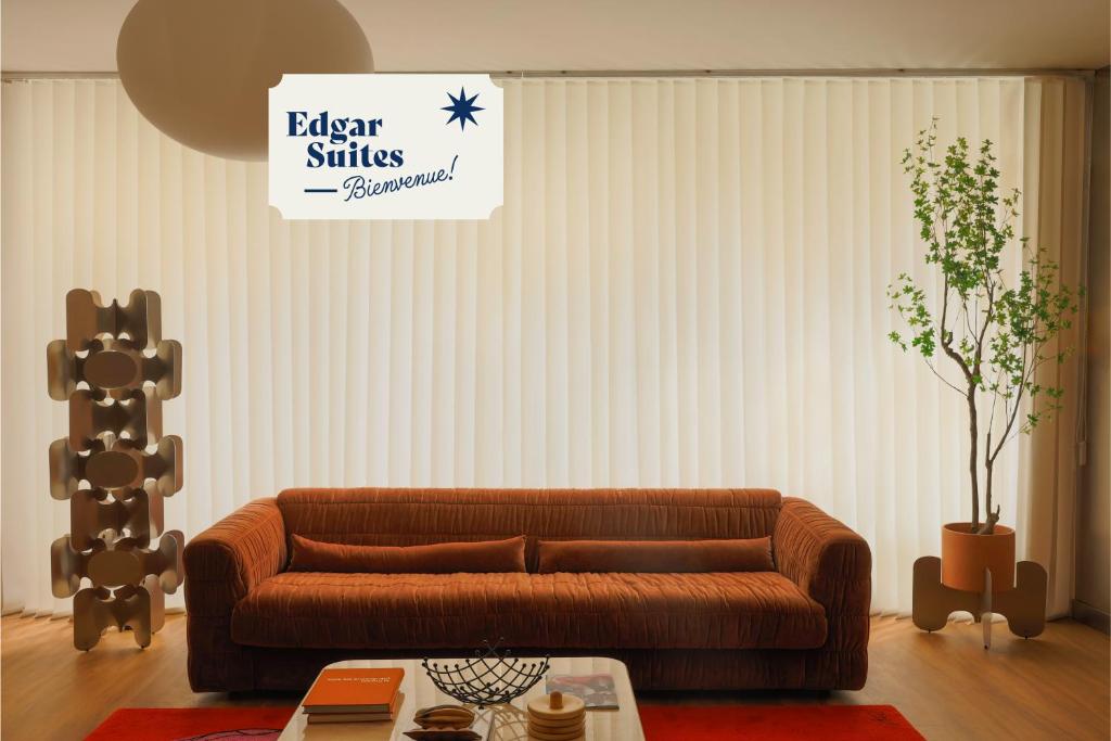 salon z brązową kanapą i drzewem w obiekcie Edgar Suites Marais - Temple w Paryżu