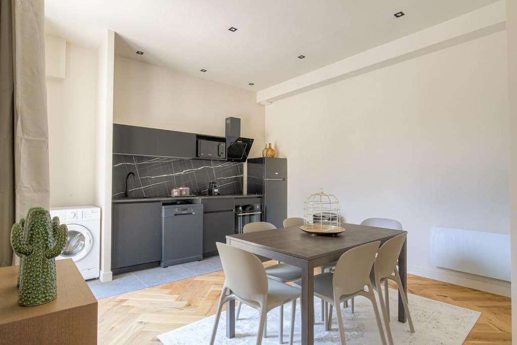 une cuisine et une salle à manger avec une table et des chaises dans l'établissement Joli T3 avec terrasse et parking, Écully, à Écully