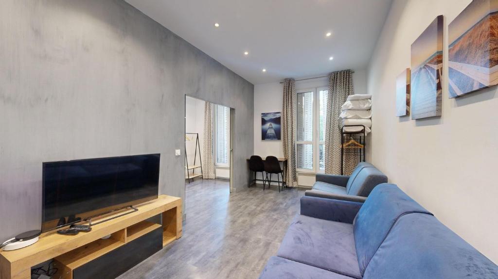 un salon avec un canapé bleu et une télévision à écran plat dans l'établissement Bluestay 63 - Appartement cozy, Paris centre, à Paris