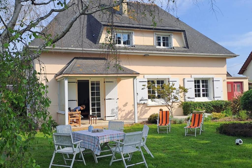 une table et des chaises devant une maison dans l'établissement Maison familiale 200 m de la mer, à Denneville-Plage