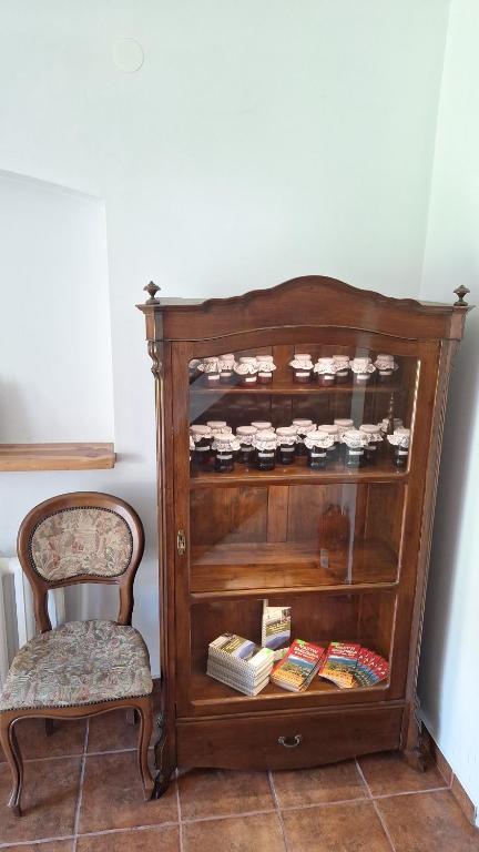 a wooden book shelf with books and a chair at Folwark in Stronie Śląskie