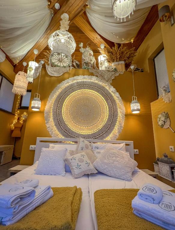a bed with white towels and a chandelier at Pino - Villa, Casa, Cucina е Terrazza in Albena