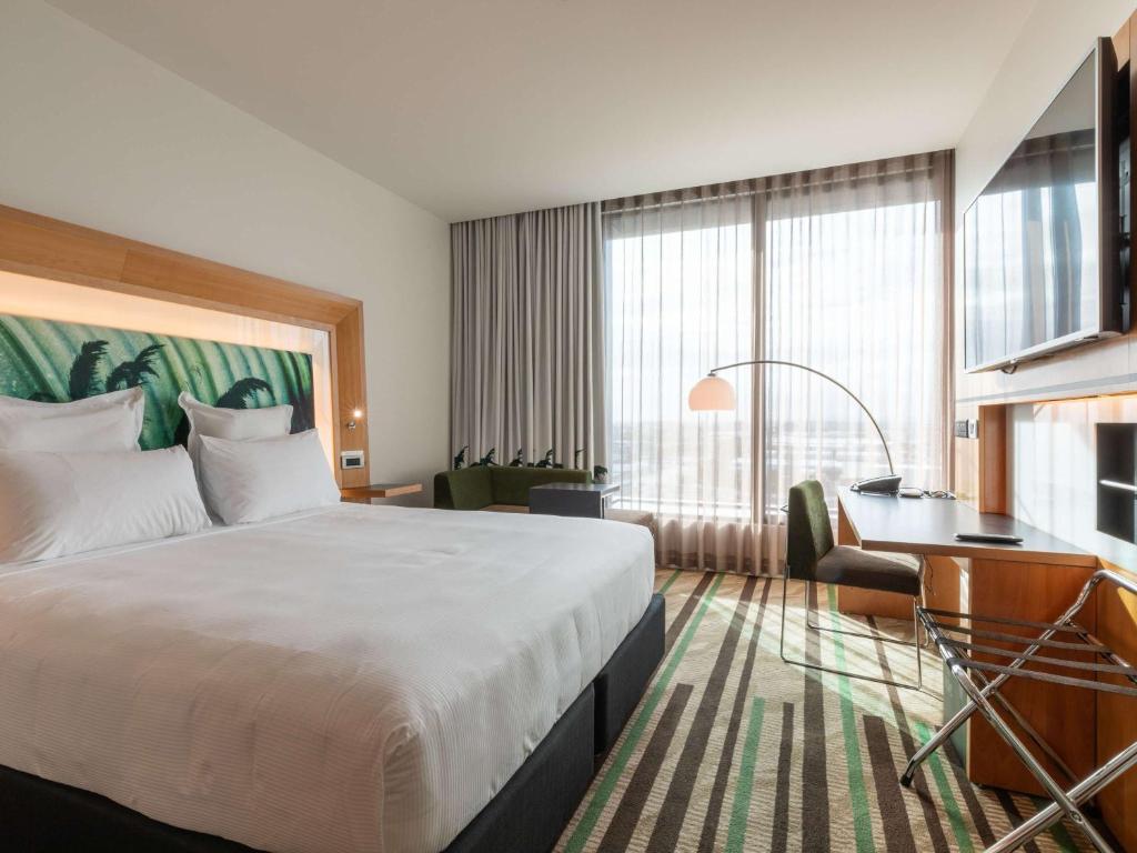 a hotel room with a bed and a desk at Novotel Auckland Airport in Auckland