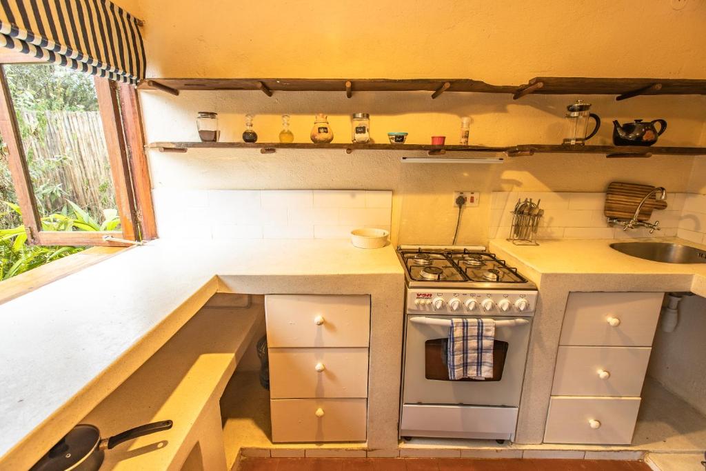 a small kitchen with a stove and a sink at Ol Losowan House and Cottages in Nairobi