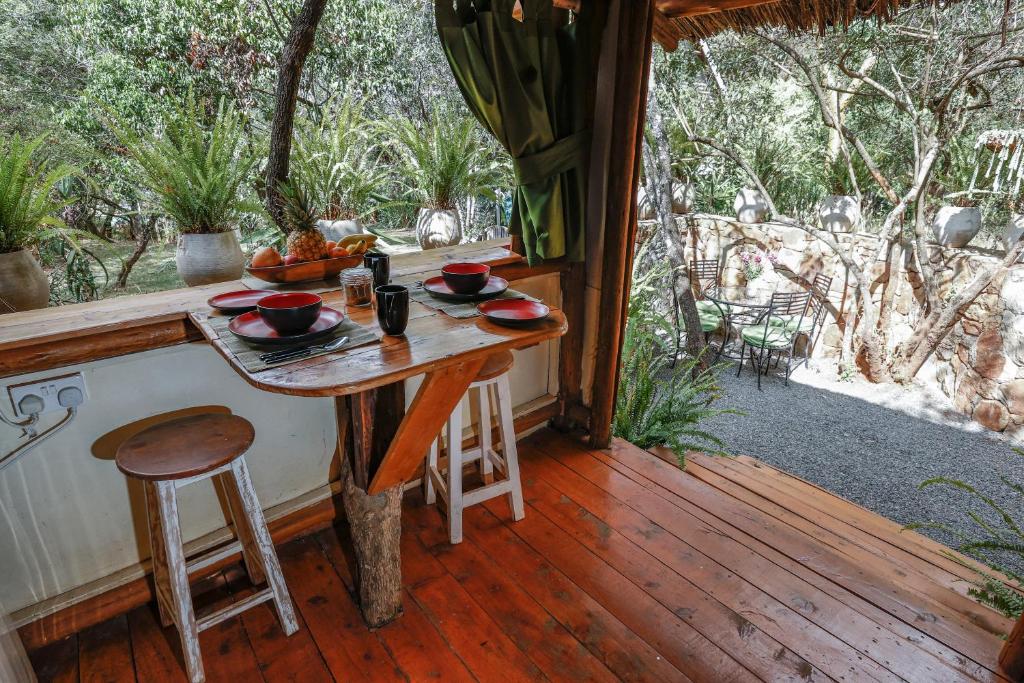 a table on the porch of a cabin with a view at Ol Losowan House and Cottages in Nairobi