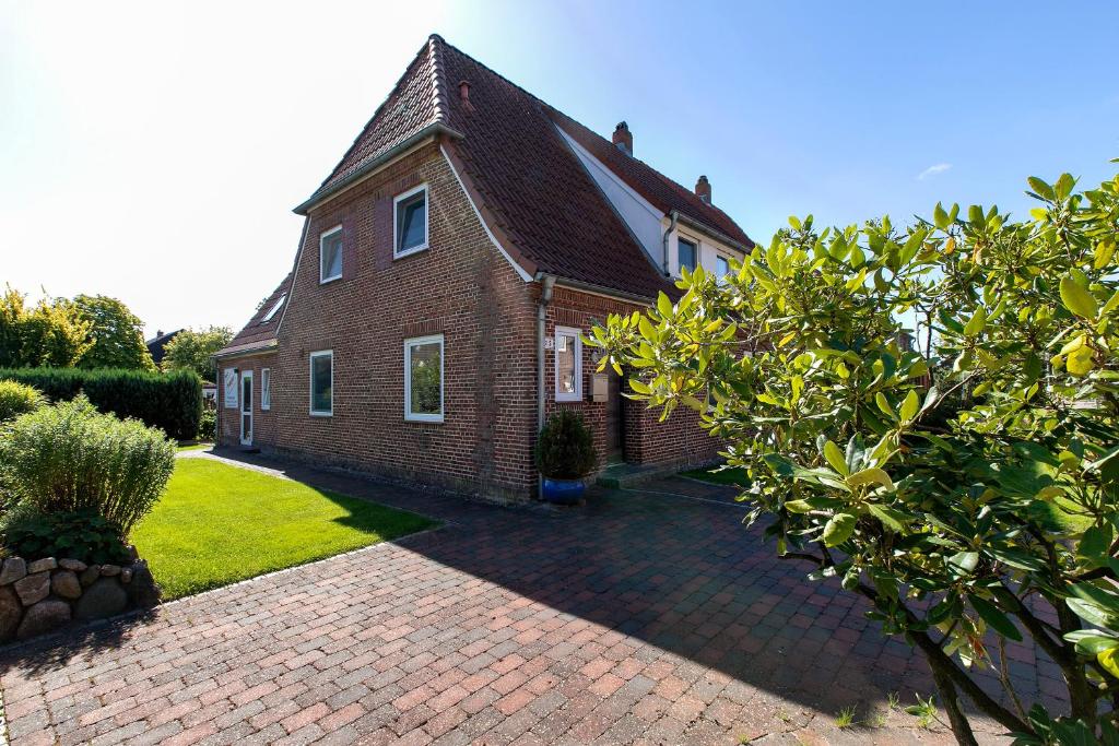 a brick house with a brick driveway in front of it at Ferienwohnung Nordfriesland in Niebüll