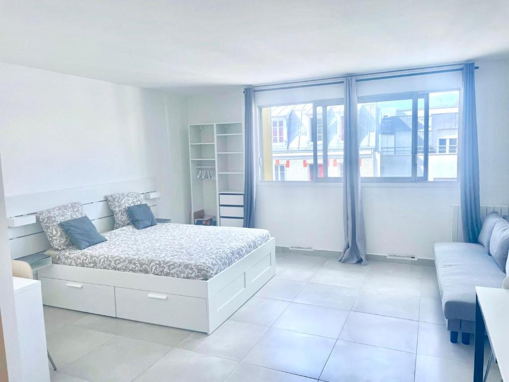 une chambre avec un lit, un canapé et une fenêtre dans l'établissement Le Petit Canotier, à Paris