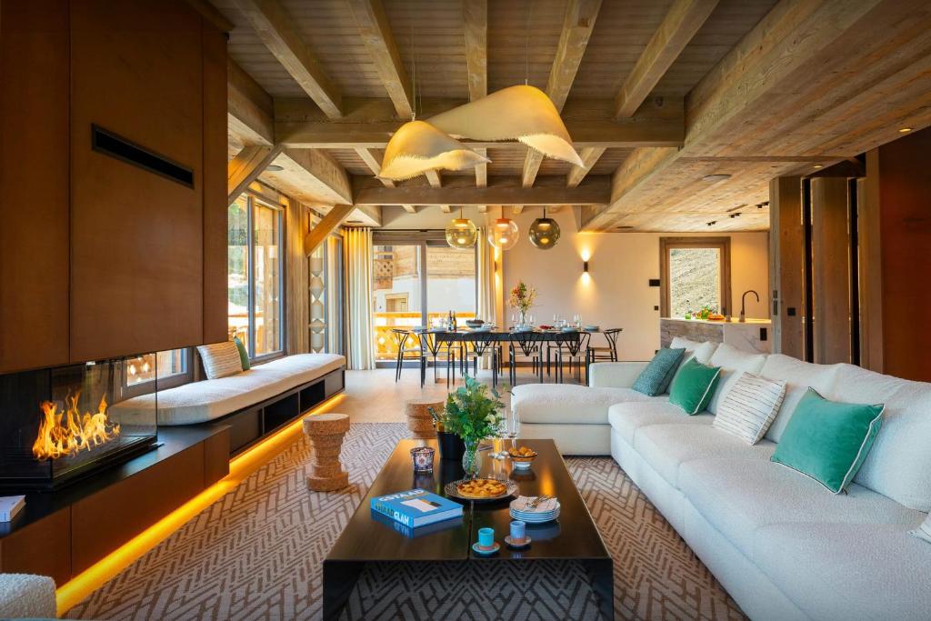 een woonkamer met een witte bank en een open haard bij Chalet Mussol - OVO Network in Saint-Gervais-les-Bains
