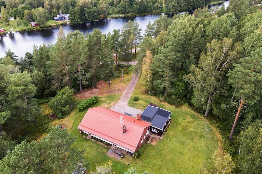 une vue aérienne d'une maison au toit rouge dans l'établissement Villa Zinkgruvan Ferienhaus am See in Alleinlage, à Zinkgruvan