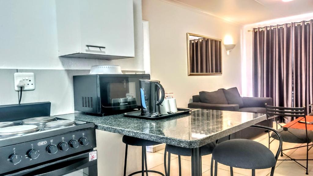 a kitchen with a counter with a microwave and a stove at Palmar Hotel in Johannesburg