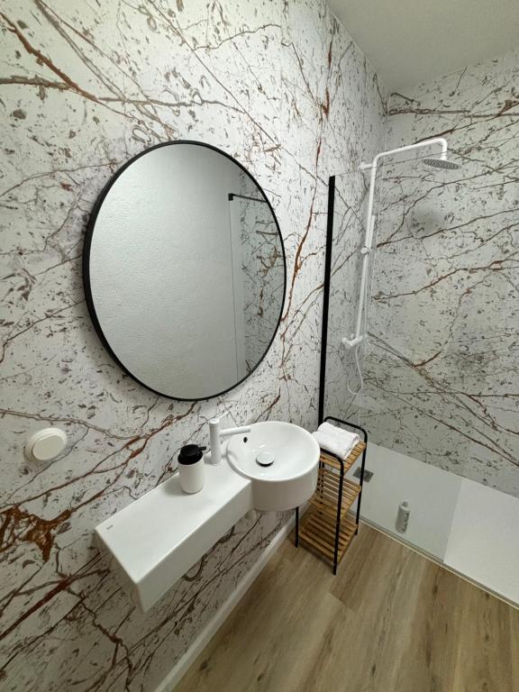 een badkamer met een witte wastafel en een spiegel bij Via Polonia - Boutique Studios Corfu in Agios Georgios