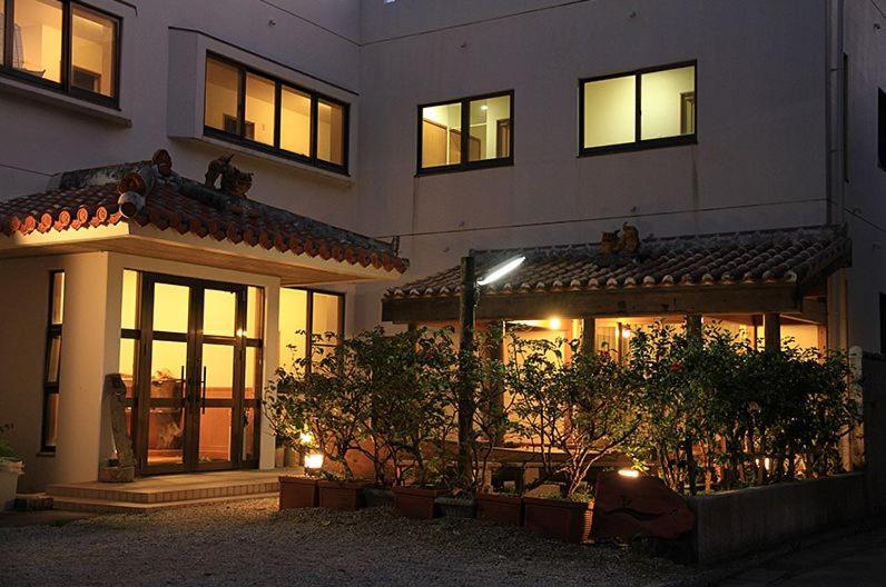a large white building with lit up windows at night at Joya in Ishigaki Island
