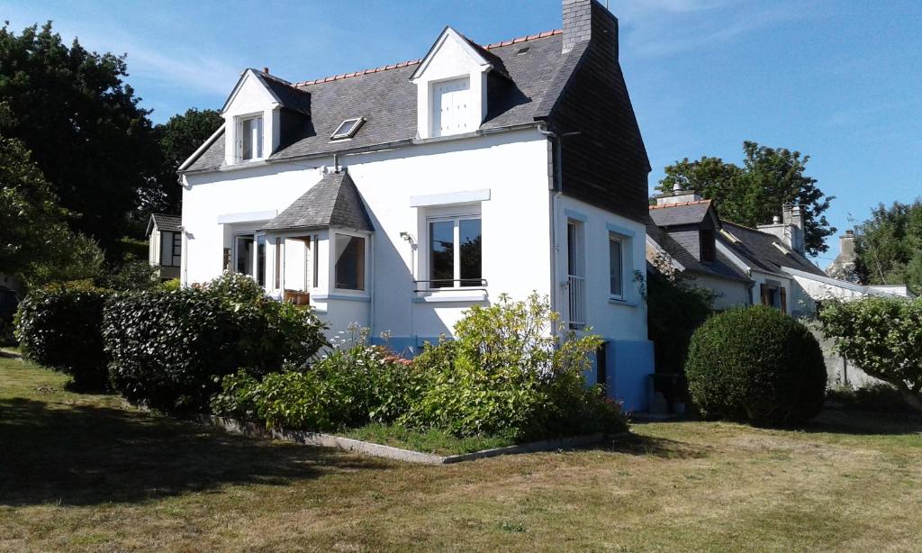 une maison blanche avec un toit noir dans l'établissement Maison de vacances à Roscanvel, à Roscanvel