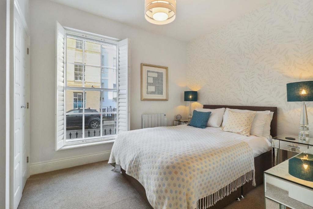 Un dormitorio con una cama grande y una ventana. en 3, Gainsborough House, en Cheltenham