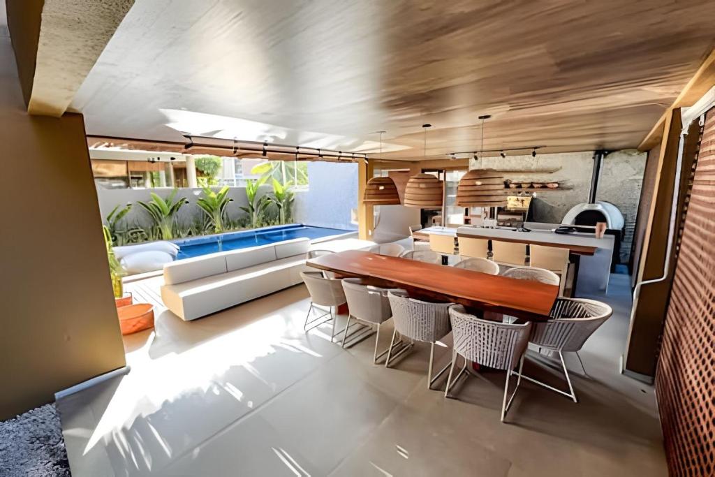 une salle à manger avec une table et des chaises dans l'établissement Casa com Ofurô, Piscina Aquecida e Cozinheira, à Barra do Camaragibe