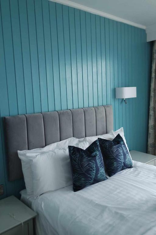 a bed with two pillows on it in a room at The Hannafore Point Hotel in Looe