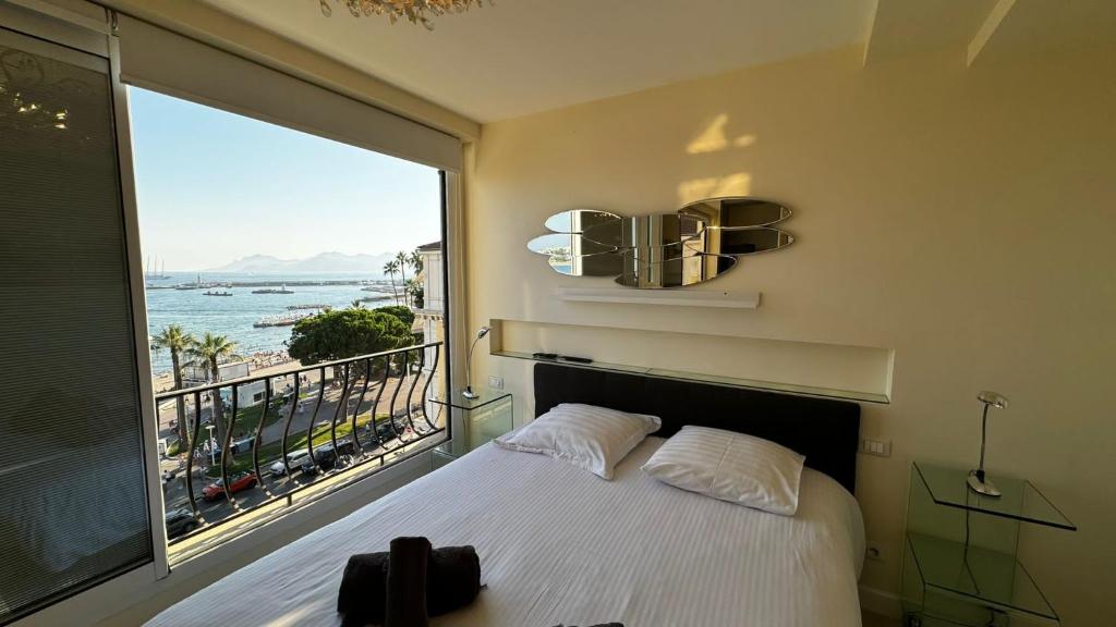 une chambre avec un lit et une grande fenêtre dans l'établissement Luxurious Cannes Two Bedrooms, à Cannes