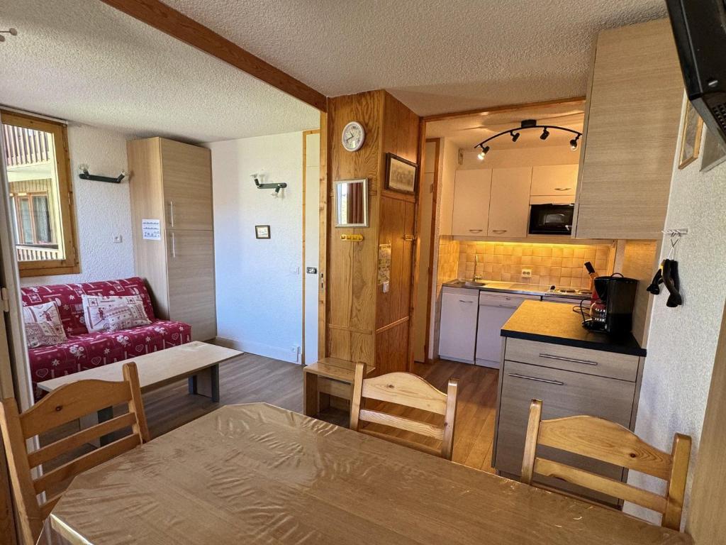 une cuisine et un salon avec une table et des chaises dans l'établissement Charmant studio divisible ski-in/ski-out avec balcon et animaux admis - FR-1-181-2129, à La Plagne Tarentaise