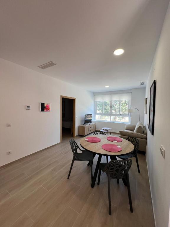 a living room with a table and chairs and a couch at Apartamentos del Raval in Gandía