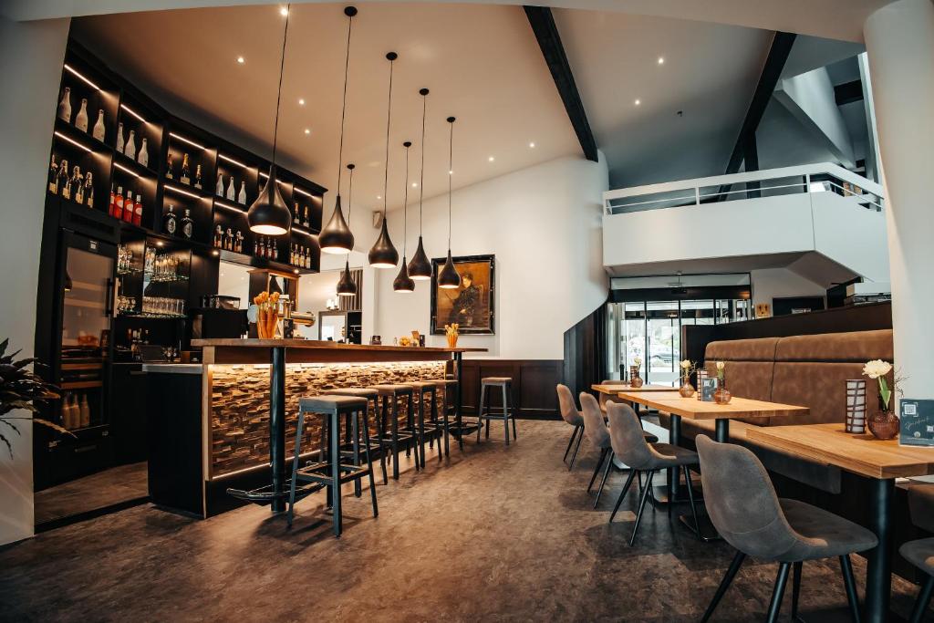 ein Restaurant mit Tischen und Stühlen und einer Bar in der Unterkunft Parkhotel Nümbrecht in Nümbrecht
