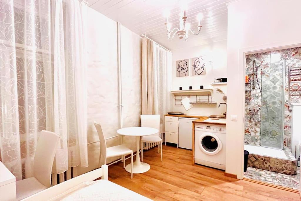 Una cocina y un comedor con mesa y sillas. en Bright and cozy old town studio!, en Tallin