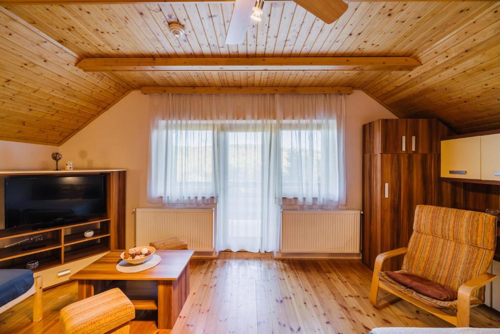 salon z dużym oknem i stołem w obiekcie Noszvaj Elite Apartman w mieście Noszvaj