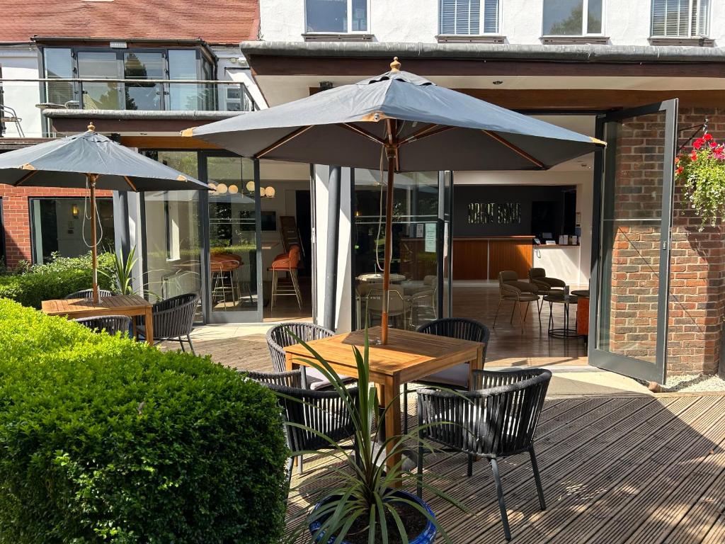 ein Tisch und Stühle mit einem Sonnenschirm auf einer Terrasse in der Unterkunft Birmingham Great Barr Hotel in Birmingham