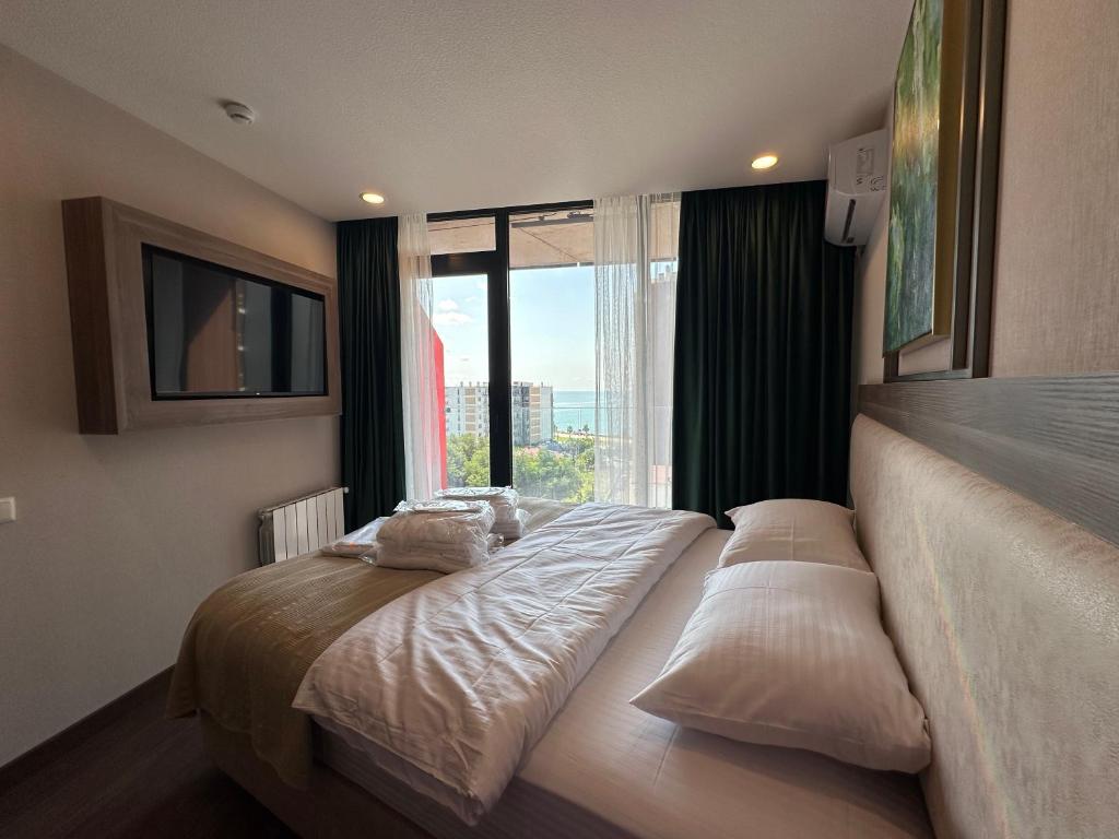 バトゥミにあるAdorable seaside apartments all with a separate bedroomの大きな窓のある部屋のベッド