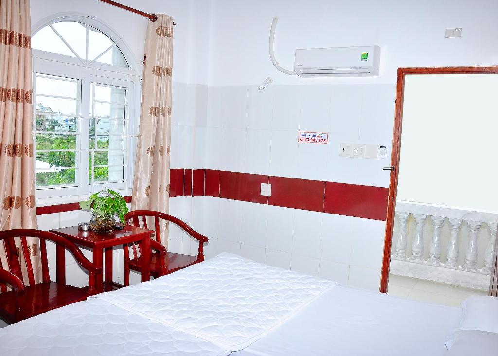 a bedroom with a bed and a table and a window at Guest House 36 (2) in Rạch Giá