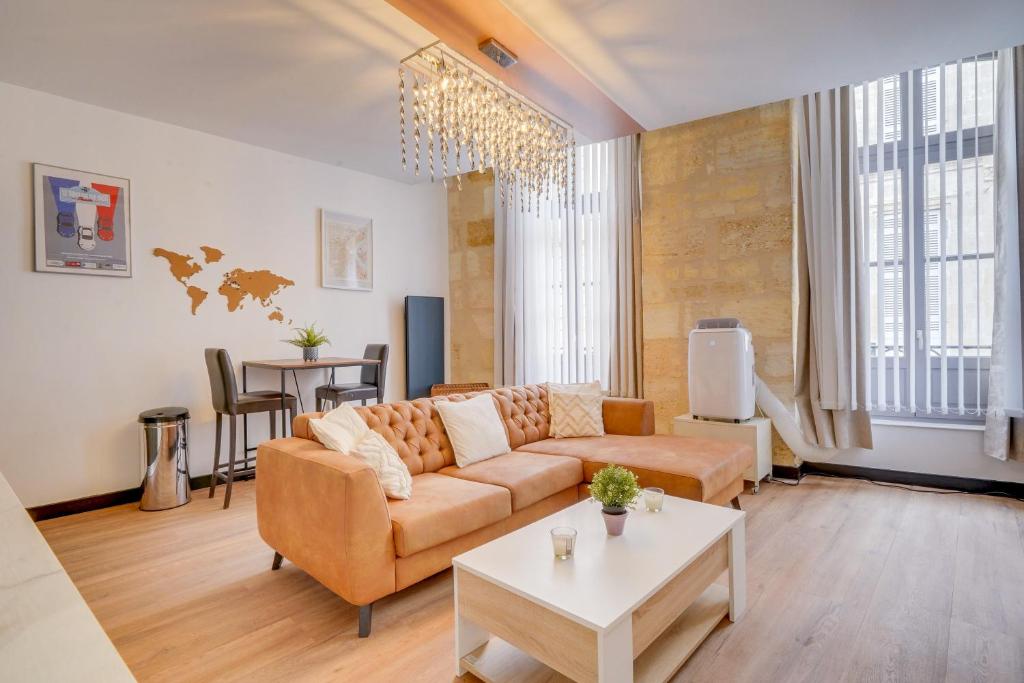 un salon avec un canapé et une table dans l'établissement Le Clos des Menuts - Appt, quartier St-Catherine, à Bordeaux