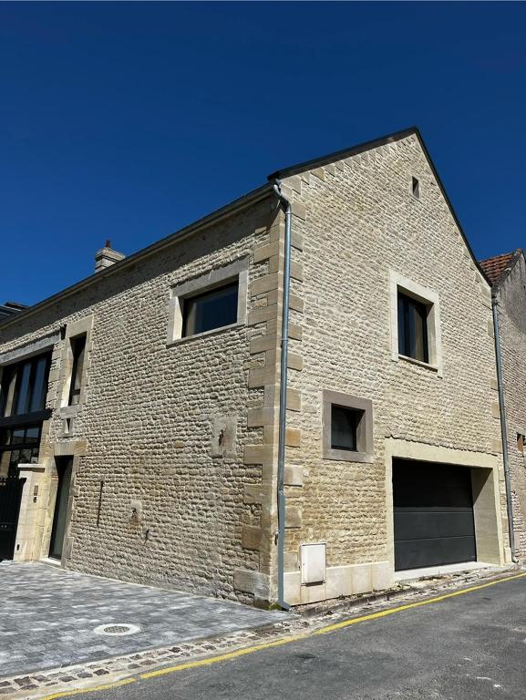 - un bâtiment en briques avec des fenêtres sur le côté dans l'établissement Maison de bord de mer, à Lion-sur-Mer
