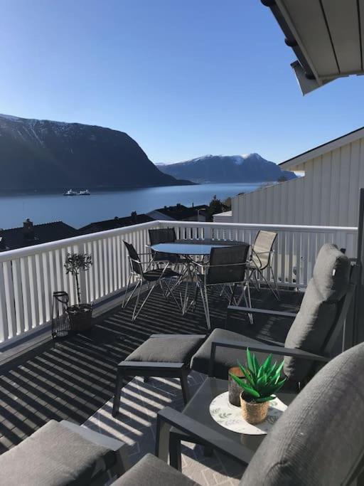 a deck with chairs and a table and a table and chairs at Hessahuset in Ålesund
