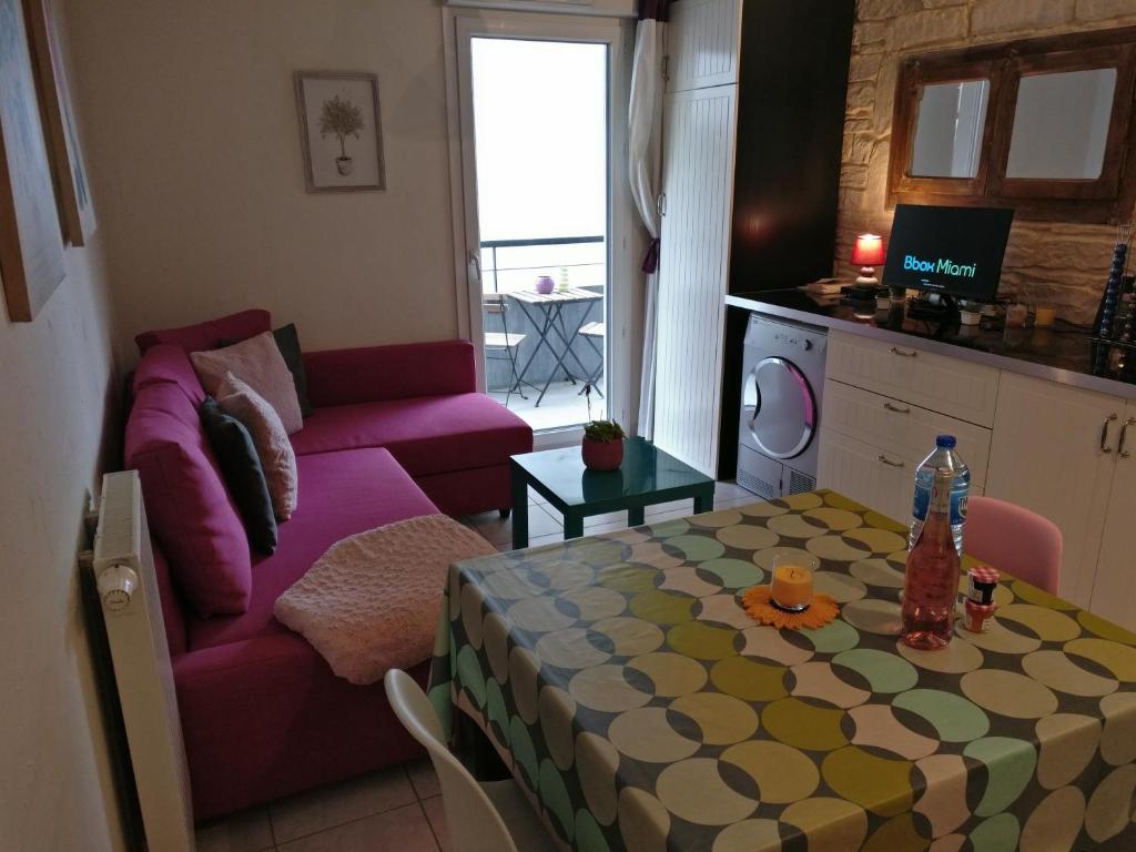 un salon avec un canapé violet et une table dans l'établissement T2 centre ville parking 19 thonon-o-phil-de-l-eau, à Thonon-les-Bains