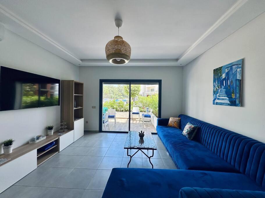 a living room with a blue couch and a table at Martil Costa-Mar in Martil