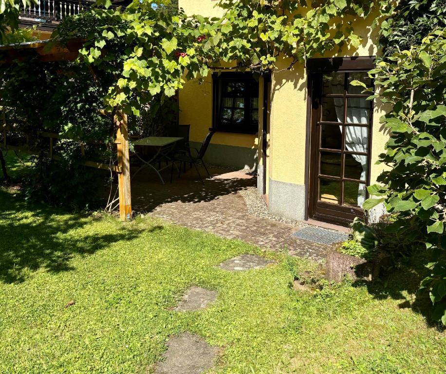 a garden with a house with a table and a tree at Ferienwohnung Hubertus in Dürrröhrsdorf