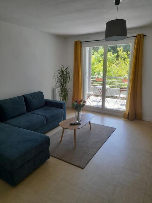 un salon avec un canapé bleu et une table dans l'établissement Appartement Avignon Décoration contemporaine, à Avignon
