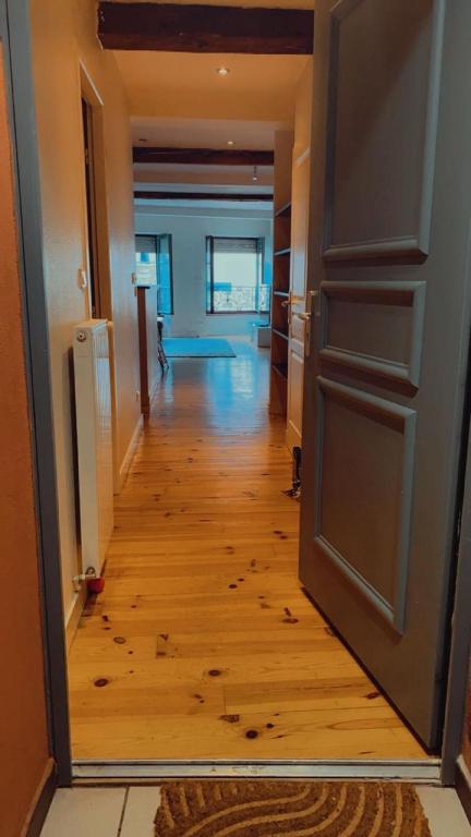un couloir vide avec une porte ouverte et une chambre dans l'établissement Hebergement la loire, à Saint-Étienne