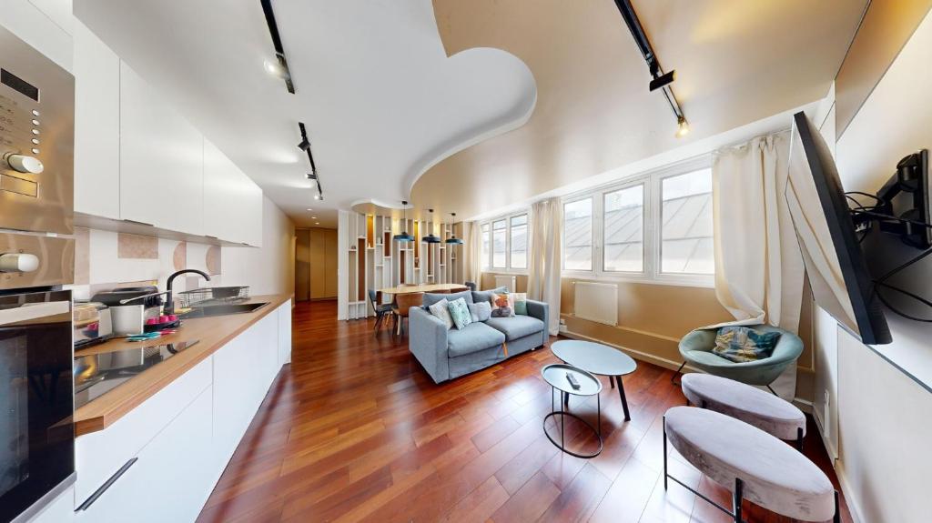 une cuisine et un salon avec un canapé et une table dans l'établissement Bluestay 87 - Magnifique Appartement à Paris, à Paris