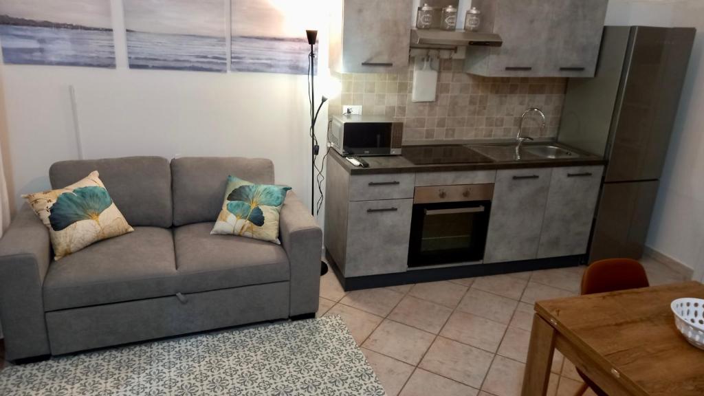 a living room with a couch and a kitchen at Casa Sabrina in Porto Torres