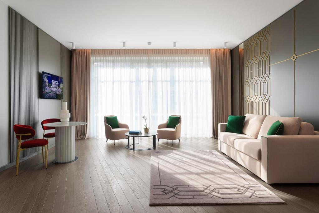 斯特雷萨Boutique Hotel Stresa的客厅里有一张沙发、几把椅子和一张桌子