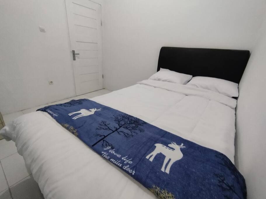 Ένα ή περισσότερα κρεβάτια σε δωμάτιο στο Kartika Homestay