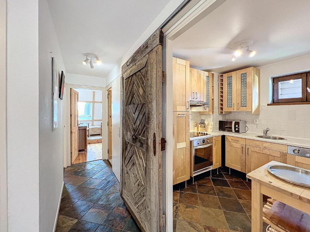 - une cuisine avec une grande porte en bois dans l'établissement Appartement Chamonix Centre, 4 Pers, 2 Ch. avec Balcon, Parking, Proche Téléphérique et Remontées - FR-1-507-24, à Chamonix-Mont-Blanc