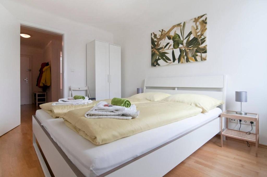 a white bed with two towels on top of it at Room in Rooftop Apartment in Vienna