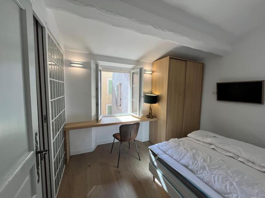 a bedroom with a bed and a desk and a window at Fishermans House Saint Tropez in Saint-Tropez